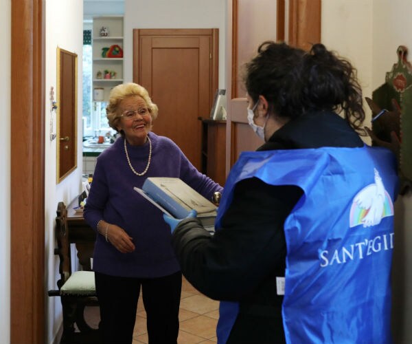 a volunteer speaks to an elderly woman during a home-care service