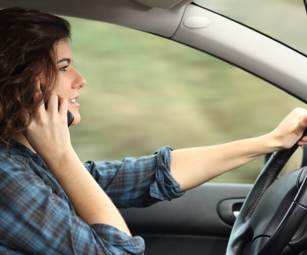 woman driving a car while talking on cellphone