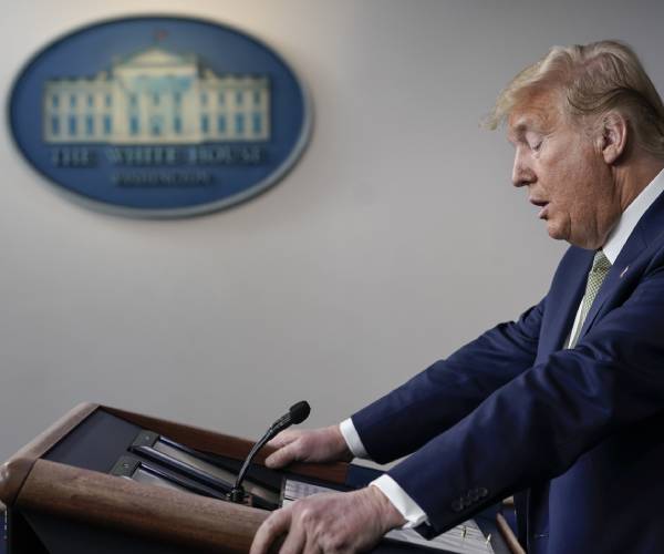president trump standing at the podium in the white house briefing room