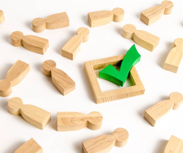 a green checkmark surrounded by wooden cutout people