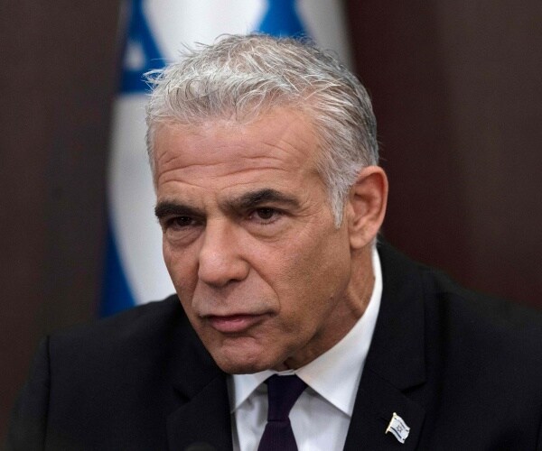 yair lapid speaks into a microphone