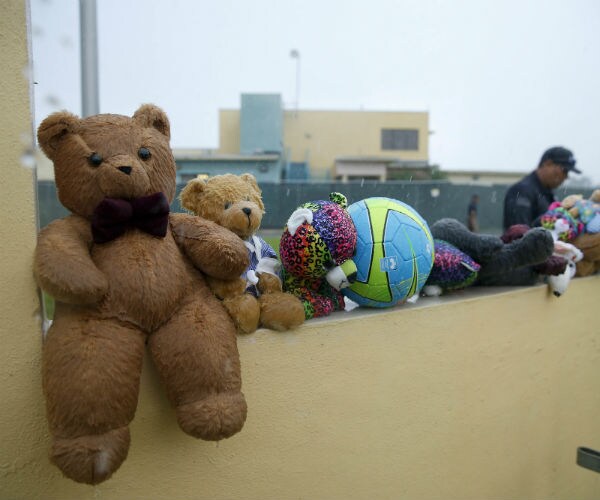 migrant detention in homestead, florida is shown with toys as a guard walks by