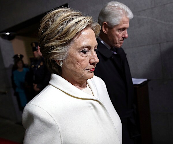 hillary clinton walks with bill clinton with their heads down