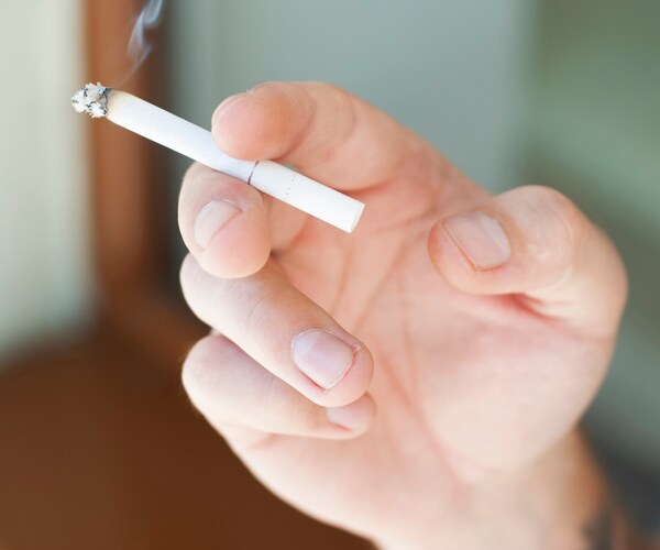 a hand holding a cigarette