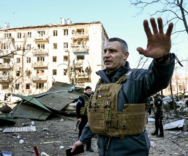 Vitali Klitschko holds people away from a five-story residential building that partially collapsed