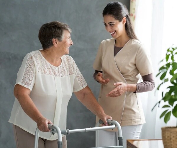 woman with Parkinson's disease walking with walker 