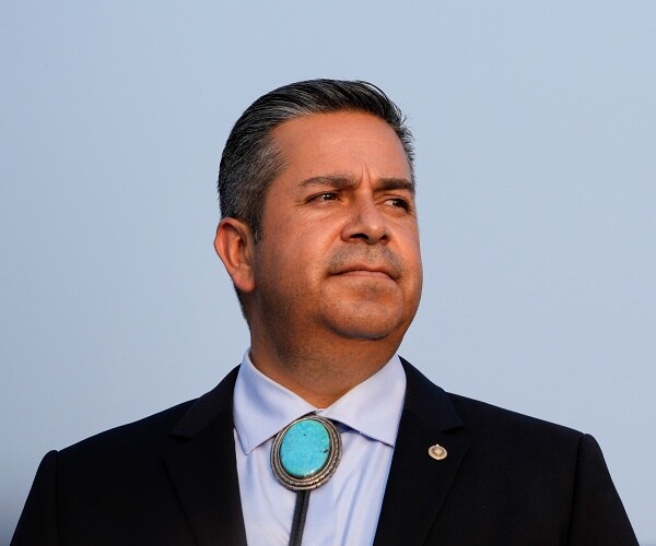 ben ray lujan stands outside