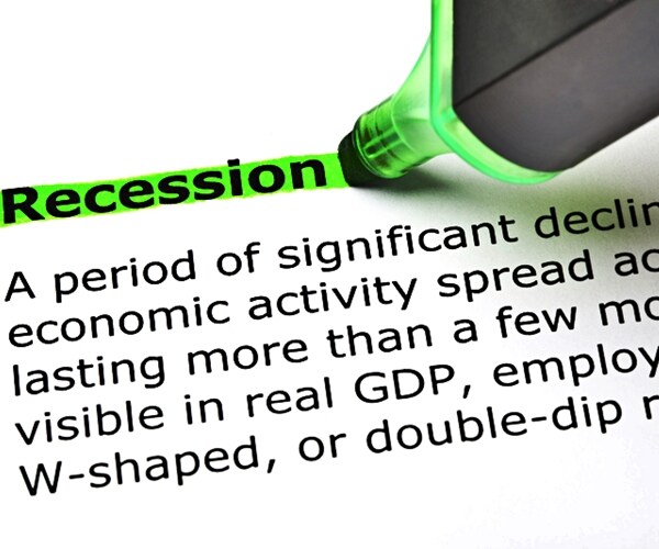 closeup shot of dictionary definition of the word Recession highlighted with green text marker. 