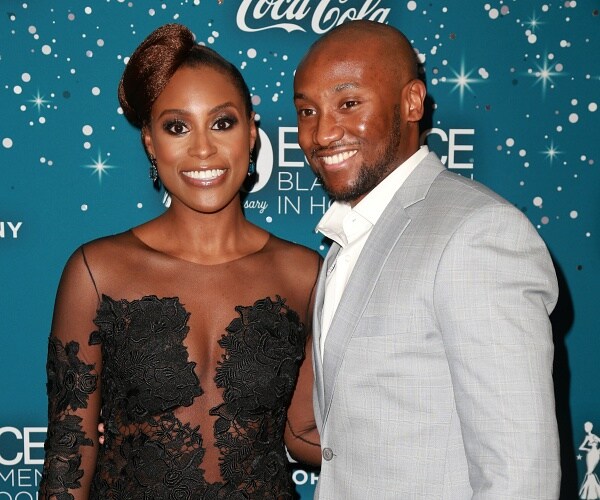 issa rae and louis diame stand on red carpet