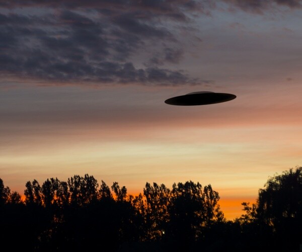 ufo during a sunset above trees