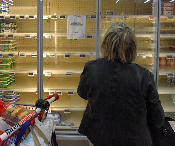 A woman reads a sign on a shelf