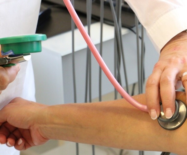 healthcare worker checking a patient's blood pressure