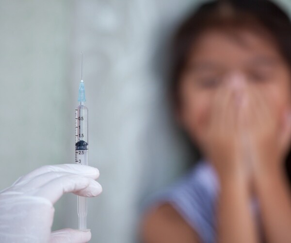 vaccine is shown near a little girl putting her hands over her mouth