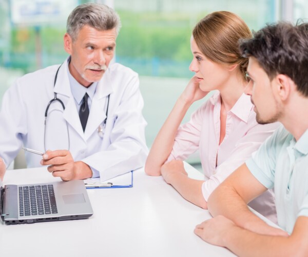 a doctor talking to a young couple