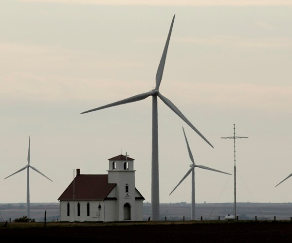 a country church sits next to wind turbines in kansas
