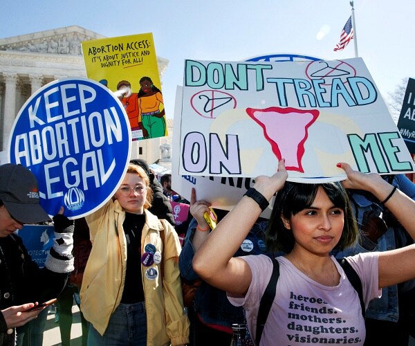 demonstrators stand outside supreme court