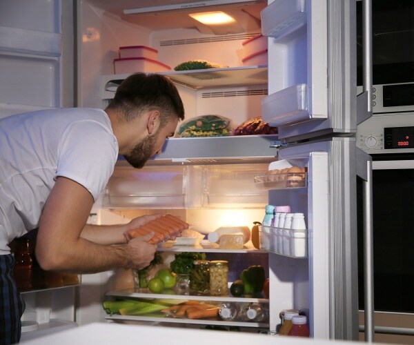man looking in his refrigerator and freezer