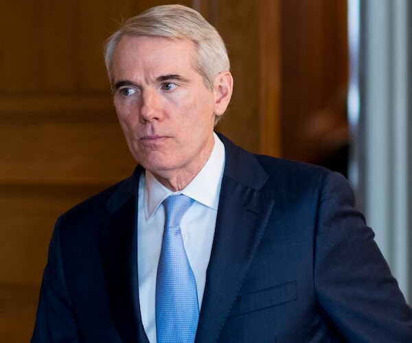 rob portman walks out of the senate chambers in the capitol building