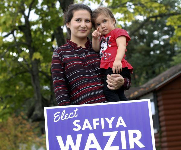 safiya wazir holds her daughter, aaliyah, behind one of her campaign signs in new hampshire. 