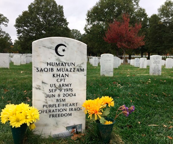 the head stone of captain humayun khan is adorned with pots of yellow flowers on both sides