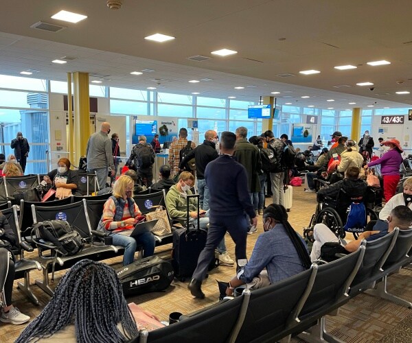 crowds are at the airport, all in masks
