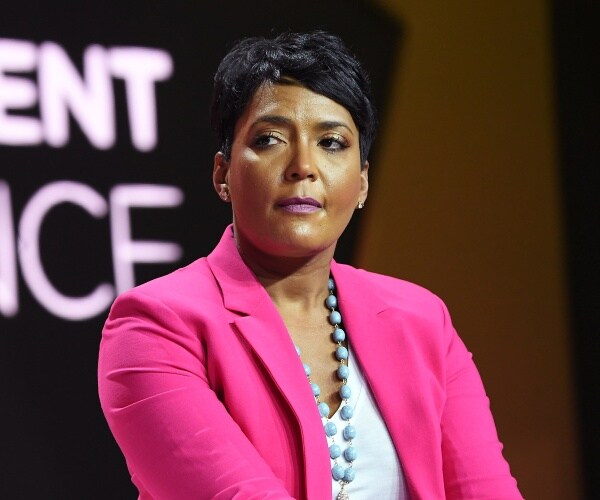 bottoms in a white top and bright pink blazer