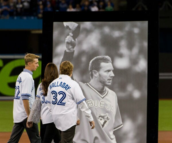 brandy halladay is shown on a baseball field with her two sons