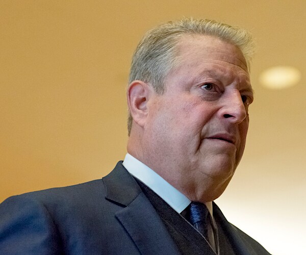 al gore walks through a hallway
