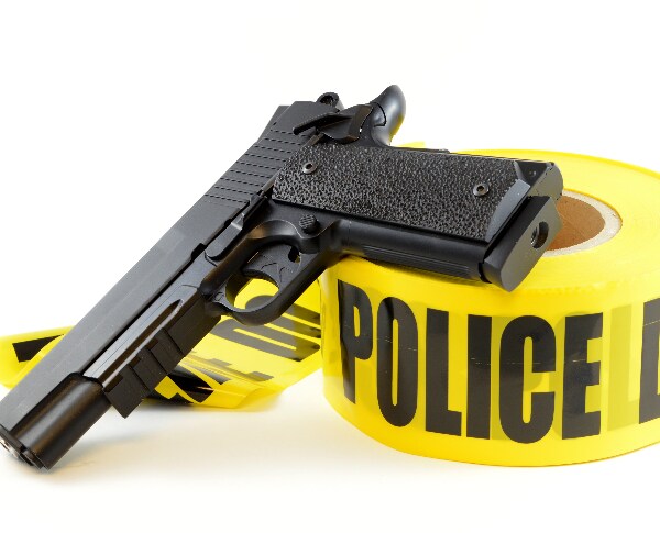 gun on a roll of caution tape