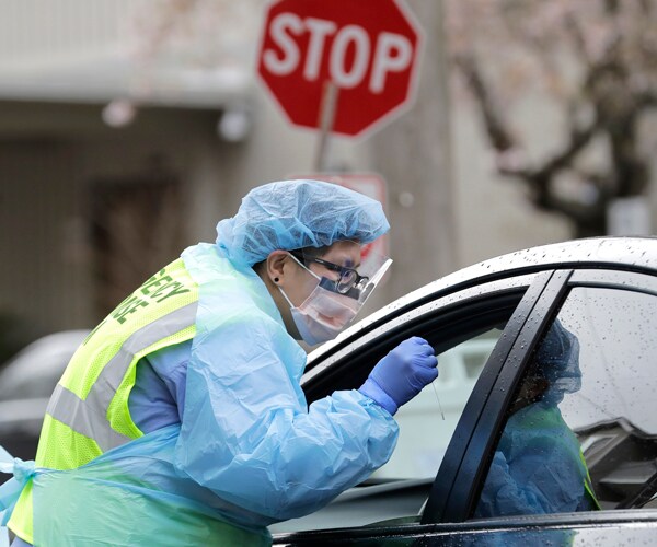 a nurse conducts a coronavirus test on a patient in seattle