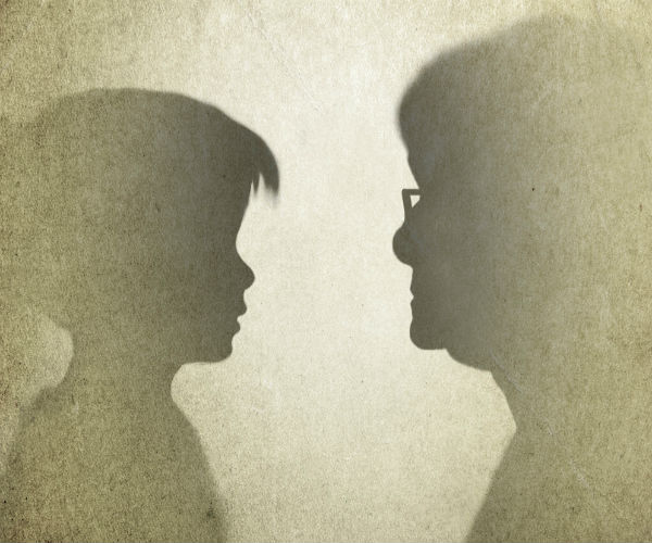 Silhouette profiles of young girl and senior adult is shown