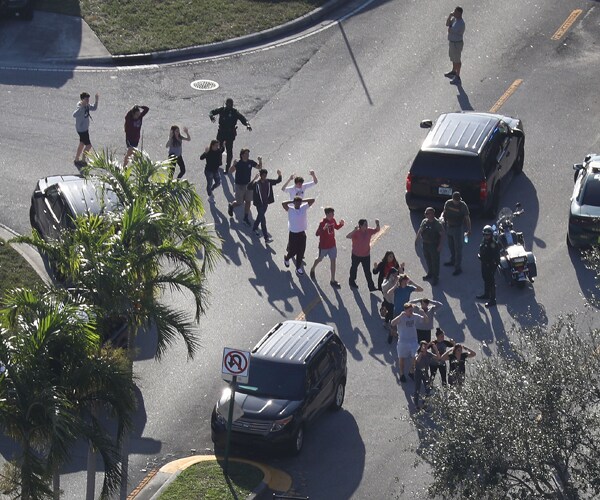 students are brought out of marjory stoneman douglas high school after a 2018 shooting there