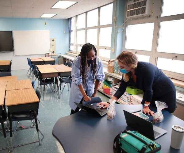 chicago elementary school teachers wear masks in an empty classroom with desks set up