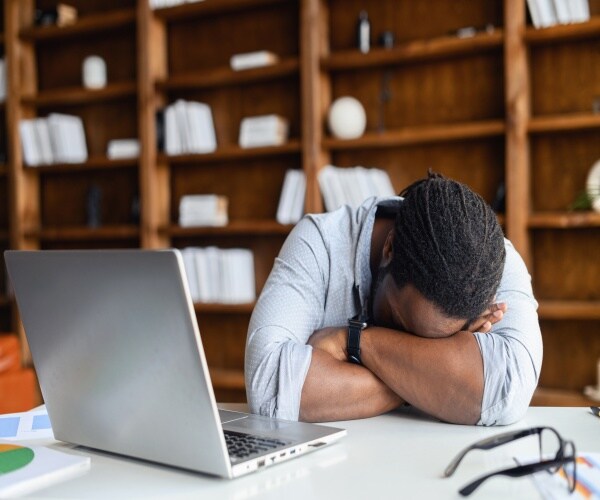 man falling asleep at his desk/computer