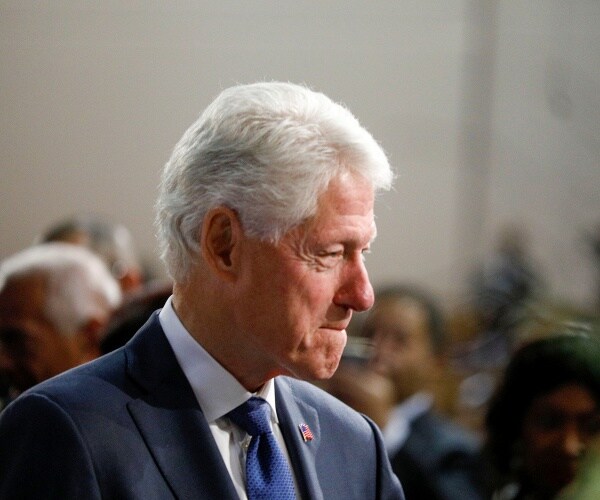 bill clinton in a suit and blue tie at a funeral for john conyers