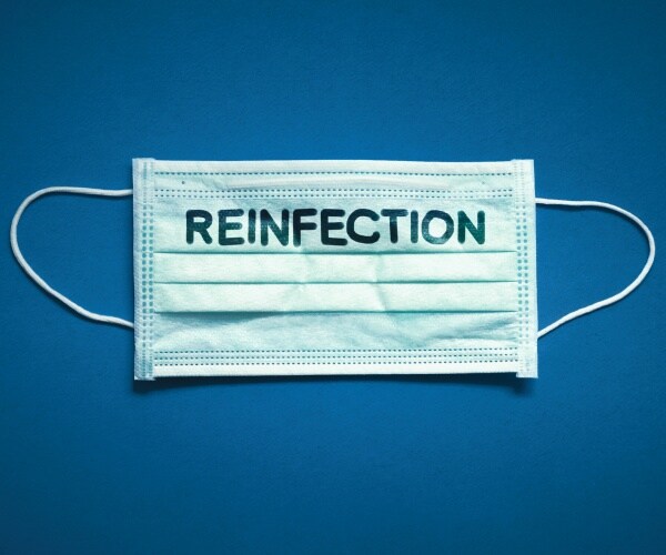 a surgical mask says reinfection