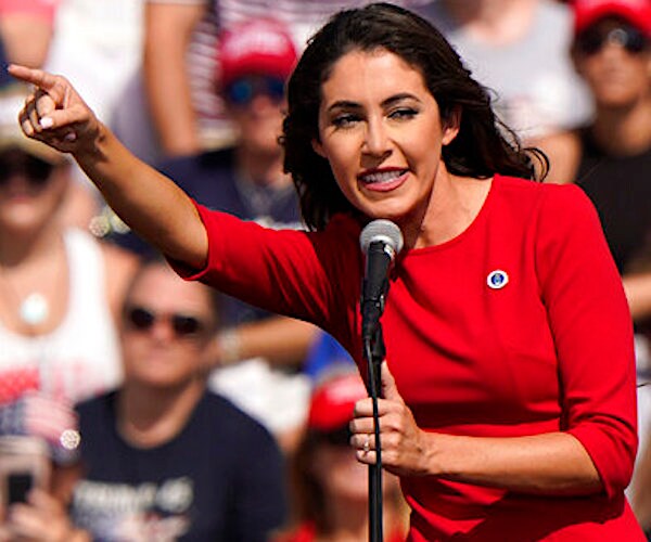 Anna Paulina Luna raises her arm at a rally while speaking into a microphone