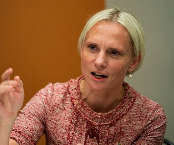 spartz in a red and white top and pearl earrings