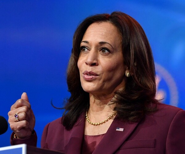 kamala harris speaks into microphone
