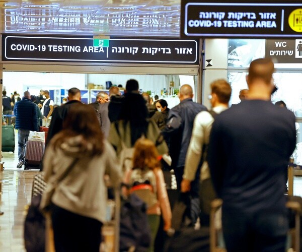 Passengers walk with their luggage upon their arrival at Ben Gurion Airport.