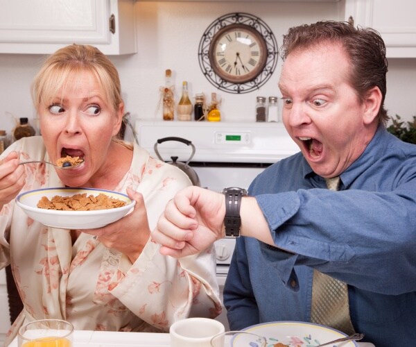 couple in kitchen having breakfast panicking because running late
