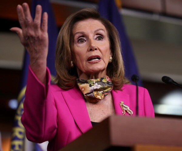 pelosi in a bright pink blazer and scarf