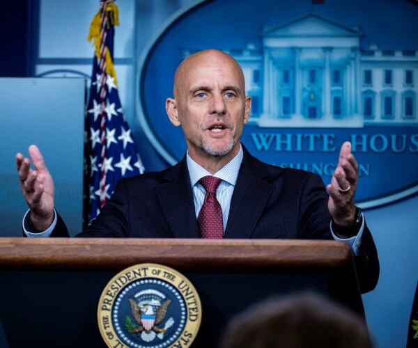 stephen hahn stands behind podium