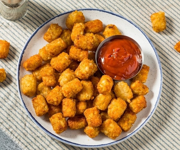 tater tots and ketchup on plate