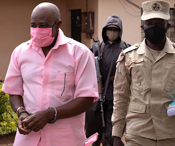 "Hotel Rwanda" hero Paul Rusesabagina (2nd L) in the pink inmate's uniform arriving at Nyarugenge Court of Justice