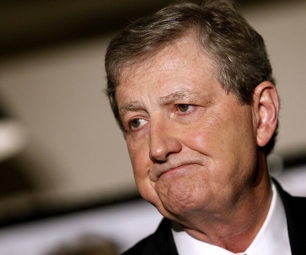 john kennedy in a suit and white shirt frowning
