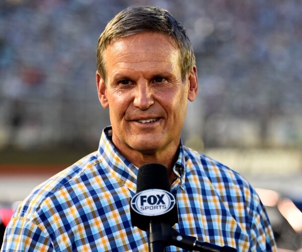 lee in a blue and yellow checkered shirt speaking into a fox mic
