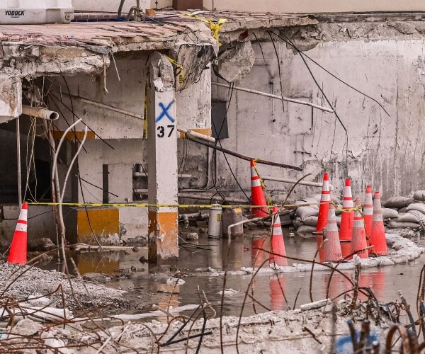 Twisted pieces of metal bars stick out of collapsed walls.