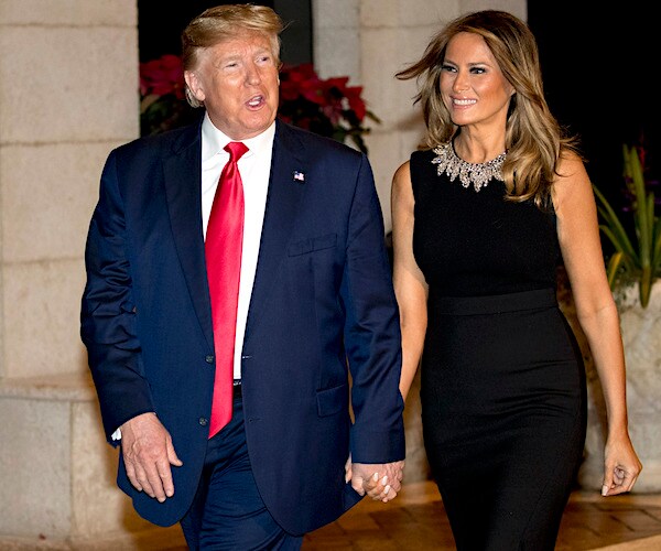 president donald trump and melania trump walk hand in hand