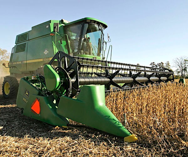 a combine rolls through a field of soybeans in ohio